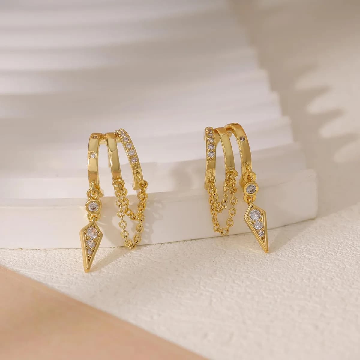 pair of gold dangle huggie earrings