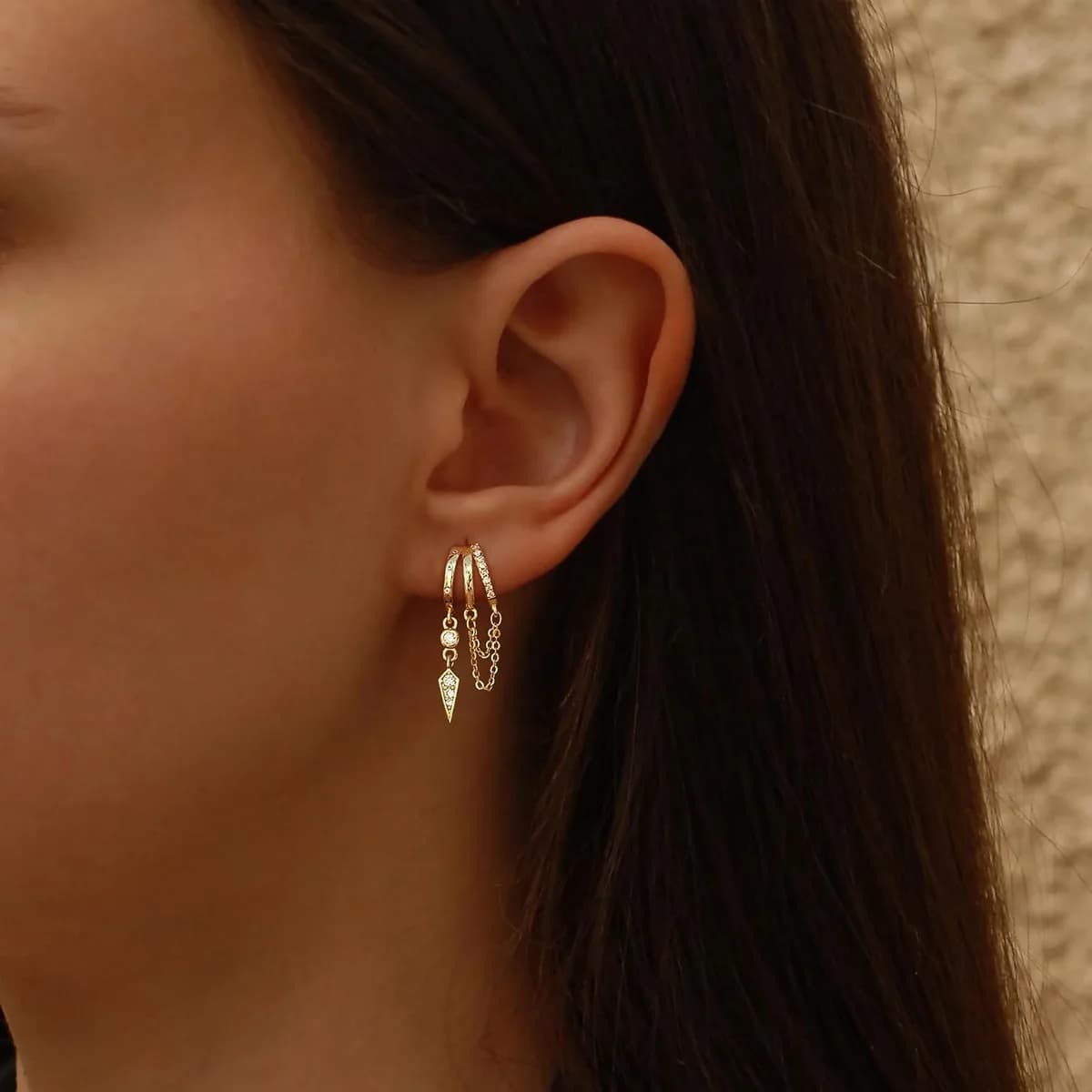 gold dangle huggie earrings on a model, product photo
